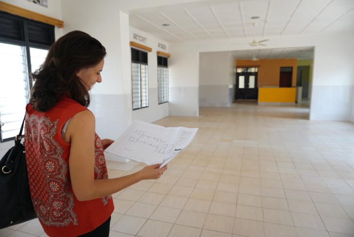 Woman in a building looking at an architectural drawing